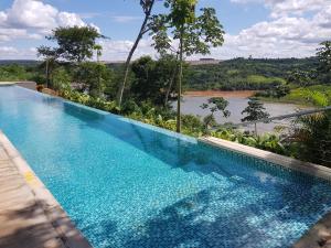 a swimming pool with a view of a river at Hotel Guaminí Misión in Puerto Iguazú