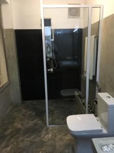 een badkamer met een douche, een toilet en een wastafel bij Dumbara Peak Residence in Kandy