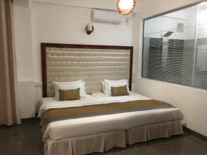 a bedroom with a large bed and a large window at Dumbara Peak Residence in Kandy