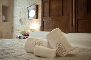 two towels sitting on top of a bed at HolidayMonopoli in Monopoli