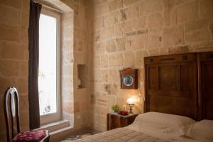 a bedroom with a bed and a window at HolidayMonopoli in Monopoli