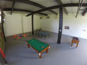 a room with a pool table and two tables at Luz da Lua Pousada in Ubatuba