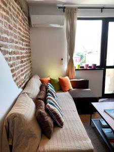 eine Couch mit Kissen darauf in einem Wohnzimmer in der Unterkunft Golden Dome view Apartment in Sofia