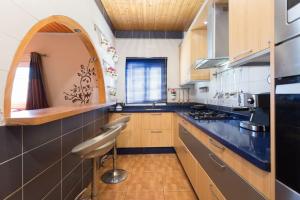 cocina con armarios de madera y encimera azul en Villa Blanca Tenerife - Private rooms - Terrace and BBQ, 5 minutes from the beach and airport, en San Isidro