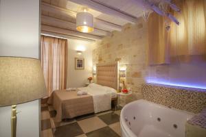 a bathroom with a tub and a bed and a bath tub at HolidayMonopoli in Monopoli