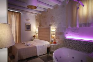a hotel room with a tub and a bed and a tub at HolidayMonopoli in Monopoli