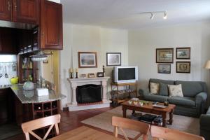 a living room with a couch and a table at Apartamento de São João in Praia da Areia Branca