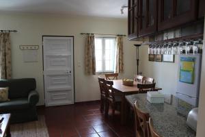 a kitchen and dining room with a table and chairs at Apartamento de São João in Praia da Areia Branca