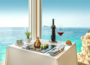 stół z talerzem jedzenia i kieliszkiem wina w obiekcie Hotel Boutique Villa Venecia w mieście Benidorm