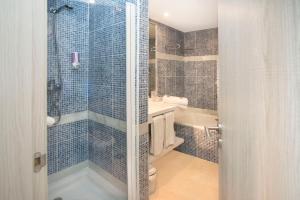 a bathroom with a shower and a toilet and a sink at Benalmadena Palace Spa in Benalmádena