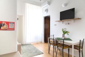 a dining room with a table with chairs and a tv at Modern and central apt in Porta Romana in Milan