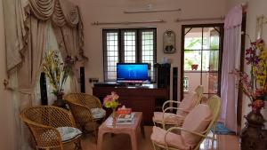 un soggiorno con TV, sedie e tavolo di Valiyathayil Home Stay a Cochin