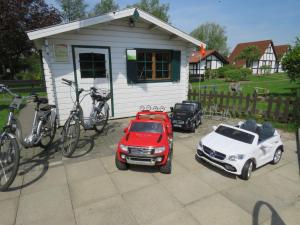 Hollern-TwielenflethにあるPremium-Ferienhaus Gala im Feriendorf Altes Land an der Elbeの車と自転車とカーポートのある家 +33枚の写真