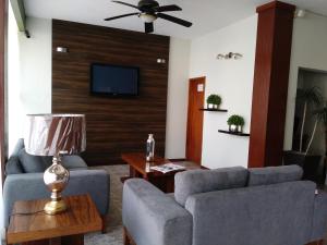 a living room with two couches and a flat screen tv at Hotel del Camino Real in El Grullo