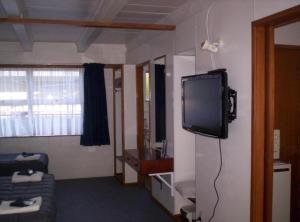 a living room with a tv and a couch at Broadway Motor Inn in Palmerston North