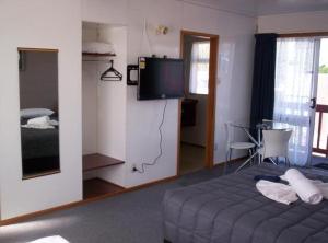 a hotel room with a bed and a television at Broadway Motor Inn in Palmerston North