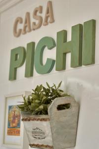 a plant in a pot sitting in front of a sign at Casa Pichi in El Pulliu