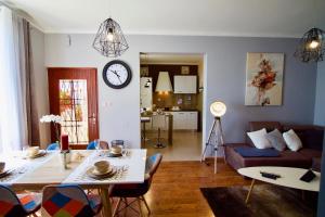 a living room with a couch and a clock on the wall at Apartman Nicole in Mošćenička Draga