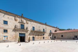 un gran edificio de piedra con un patio delante de él en Eurostars Monumento Monasterio de San Clodio Hotel, en Leiro