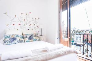 a white bedroom with a bed with a window at Triana Sky View by Valcambre in Seville