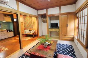 a living room with a table and a kitchen at Koi Koi in Takamatsu