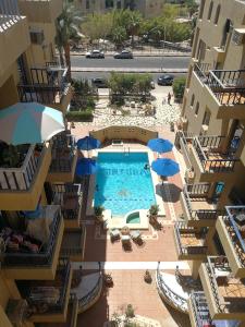 einen Blick über einen Pool mit Sonnenschirmen in der Unterkunft Cordoba Suites in Hurghada