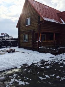 a log house with snow on the ground in front of it at "У вуйка" in Uzhhorod