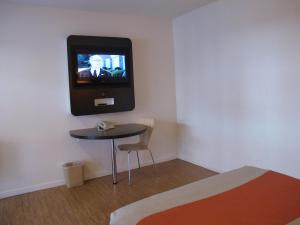 a room with a small table and a tv on the wall at Motel 6 Baltimore MD in Baltimore