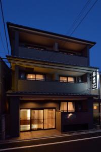 un bâtiment avec une façade éclairée la nuit dans l'établissement UU Inn Kyoto, à Kyoto