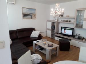 ein Wohnzimmer mit einem Sofa und einem TV in der Unterkunft Apartman Sanja in Ploče