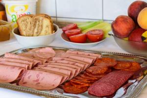 a tray of food with meats and bread and fruit at Star Beach Resort in Makrygialos