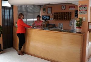 two women standing at a counter at a restaurant at Hotel Canad&aacute; in Toluca