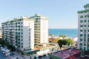 a city with two tall buildings next to the ocean at Habitaciones frente a la playa in Málaga