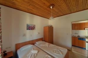 una camera con 2 letti e un soffitto in legno di White Rock Apartments a Marathokampos