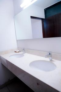 a bathroom with two sinks and a mirror at EH Ejecutivo Urban in Tepic