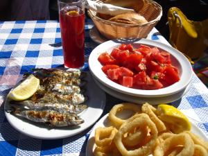 a table with two plates of food with fish and onion rings at Habitaciones frente a la playa in Málaga +19 photos