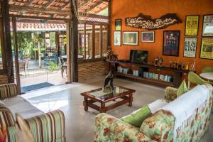 a living room with a couch and a coffee table at Pousada Estalagem Vila Tania in Itaúnas