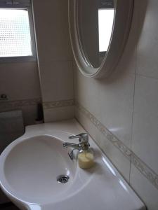 La salle de bains est pourvue d'un lavabo blanc et d'un miroir. dans l'établissement Casa del Agüista, à Marmolejo