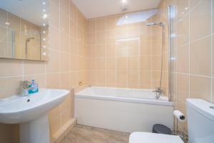 ein Badezimmer mit einer Badewanne, einem Waschbecken und einem WC in der Unterkunft Marlborough Hall Majestic Apartment - Quiet in Nottingham
