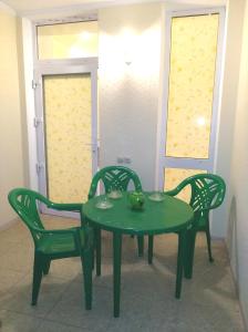 une table et des chaises vertes dans une pièce dans l'établissement Апартаменты с садом "Дача", à Kislovodsk