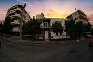 un edificio en una calle con una puesta de sol en el fondo en Zefyros Super Cool Apartments next to Alimos Riviera, en Atenas