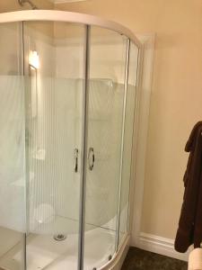 um chuveiro com uma porta de vidro na casa de banho em Arnold's Cove Inn em Arnold's Cove