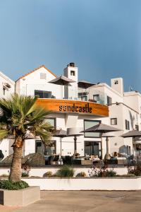um edifício com uma placa que lê castelo de areia em Sandcastle Hotel on the Beach em Pismo Beach