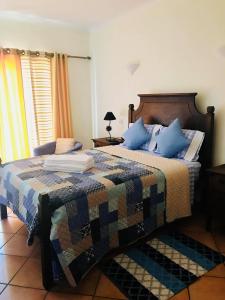 a bedroom with a large bed with blue pillows at Bella & Gordinho GuestHouse in Lagos