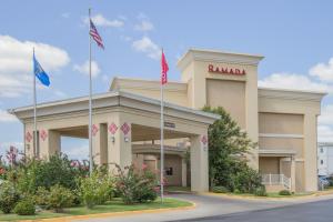 a ramada building with flags in front of it at Ramada by Wyndham Tulsa in Tulsa