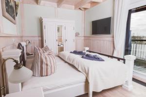 a bedroom with two beds and a tv on the wall at Penthouse Meerblick in Dierhagen