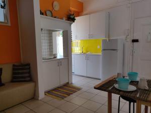 リスボンにあるCampo Santana Apartmentの白いキャビネットとテーブル付きのキッチンが備わります。