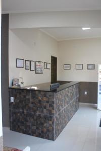 a lobby with a tile counter in a building at Pousada Do Mineiro in Olímpia