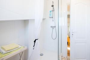 a white bathroom with a shower with a glass door at Petit studio Saint-Front- Small studio flat Saint-Front in Périgueux