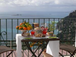 un tavolo con un cesto di frutta sul balcone di L'Uliveto a Positano